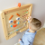 Zbliżenie na ruchome elementy tablicy MASTERKIDZ — pokrętła, suwak i ikony emocji do ćwiczeń