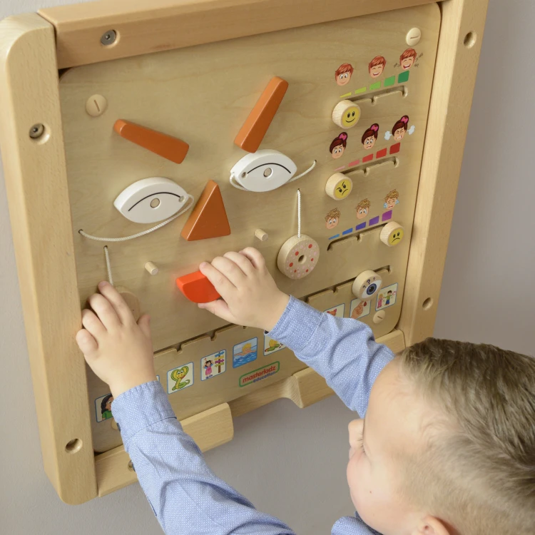 Dłoń pokazuje skalę elementów na tablicy — przyjazne rozmiary i ergonomia projektu MASTERKIDZ