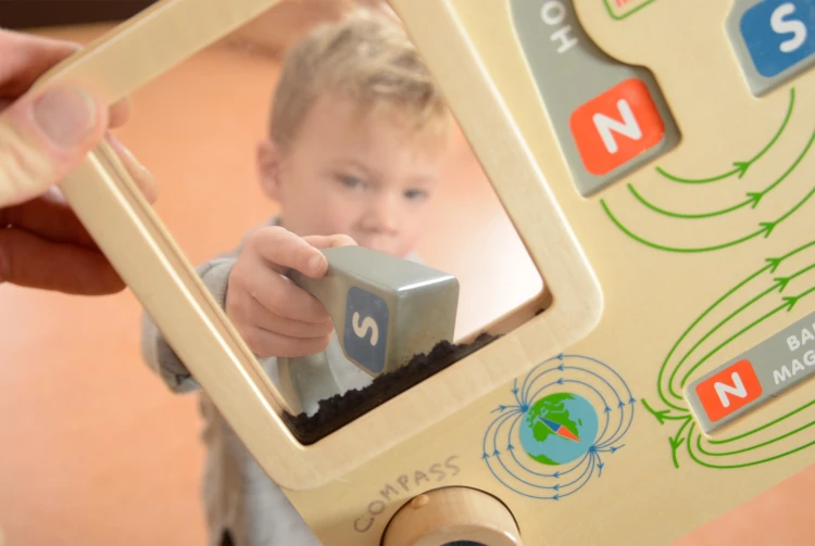 Kadr pokazuje magnetyczne elementy w różnych kolorach na edukacyjnej tablicy Montessori