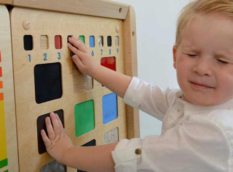 Dziecko dotyka różne faktury na tablicy edukacyjnej MASTERKIDZ — zabawa sensoryczna i nauka rozpoznawania