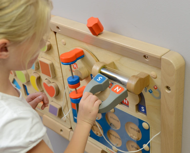 Dziecko manipuluje elementami magnetycznymi na tablicy MASTERKIDZ — interaktywna nauka przyciągania