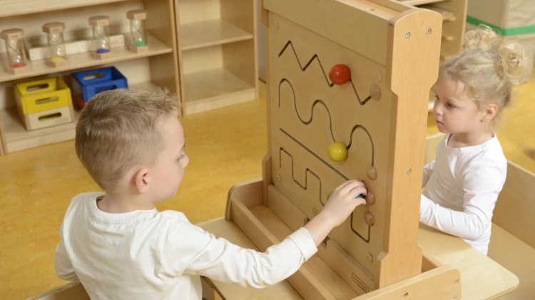 Dziecko ćwiczy palcami przesuwając elementy — Tablica Przesuwna Mała Motoryka Montessori 55 jako pomoc edukacyjna