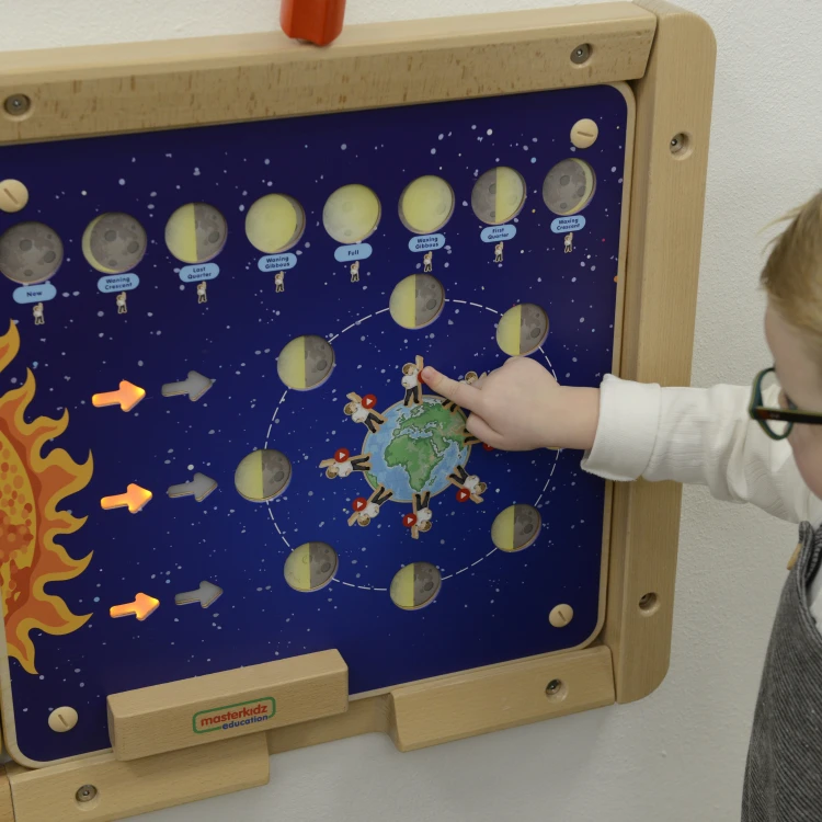Detal tablicy: wypukłe elementy faz Księżyca, ruchome kołki i czytelne ilustracje w stylu Montessori