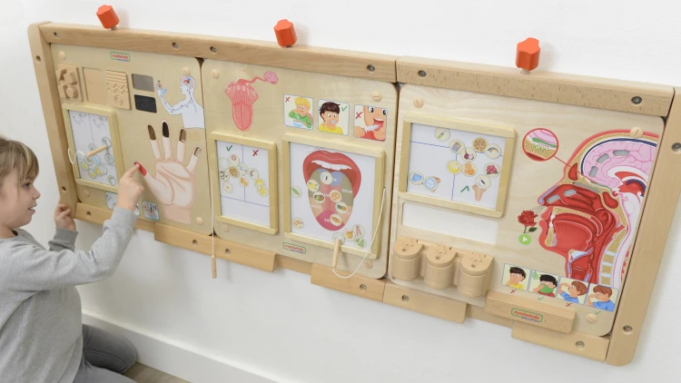 Detal zatrzasków i suwaków na Tablicy Edukacyjnej Montessori — ćwiczenie precyzji palców i koordynacji ręka-oko.