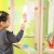 Dziecko maluje na przezroczystej sztaludze CLASSIC WORLD EDU — widok z profilu, miejsce pracy młodego artysty