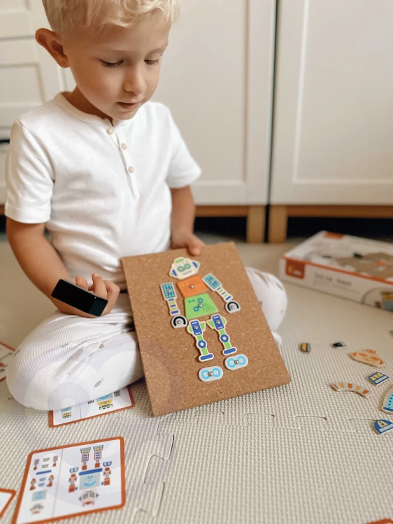 Plansza z rozmieszczonymi otworami i kolorowymi robotami — edukacyjna przybijanka VIGA w detalach