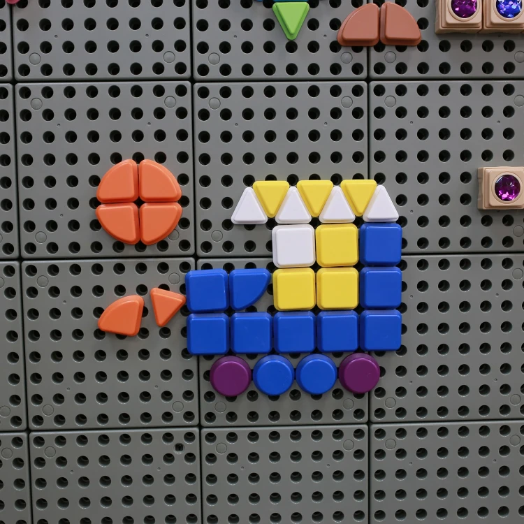 Fragment tablicy manipulacyjnej z kołeczkami MASTERKIDZ — elementy wpinane w otwory planszy w praktyce