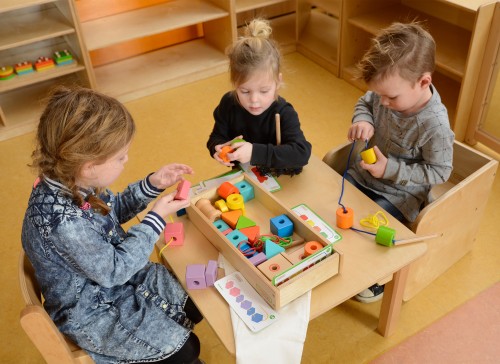 Zbliżenie na kolorowe drewniane koraliki nawlekanki MASTERKIDZ — widoczne otwory do sznurowania