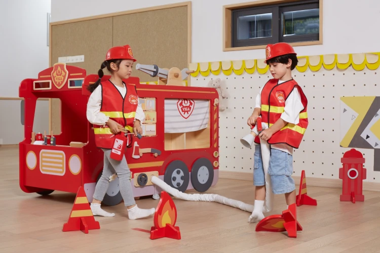 Widok z boku wozu strażackiego VIGA — uchwyt, kolorowe elementy i naturalne wykończenie drewna