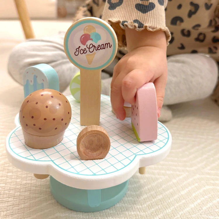 Drewniane lody magnetyczne TOOKY TOY — elementy ułożone obok zabawkowej kuchni, kolorowe warstwy