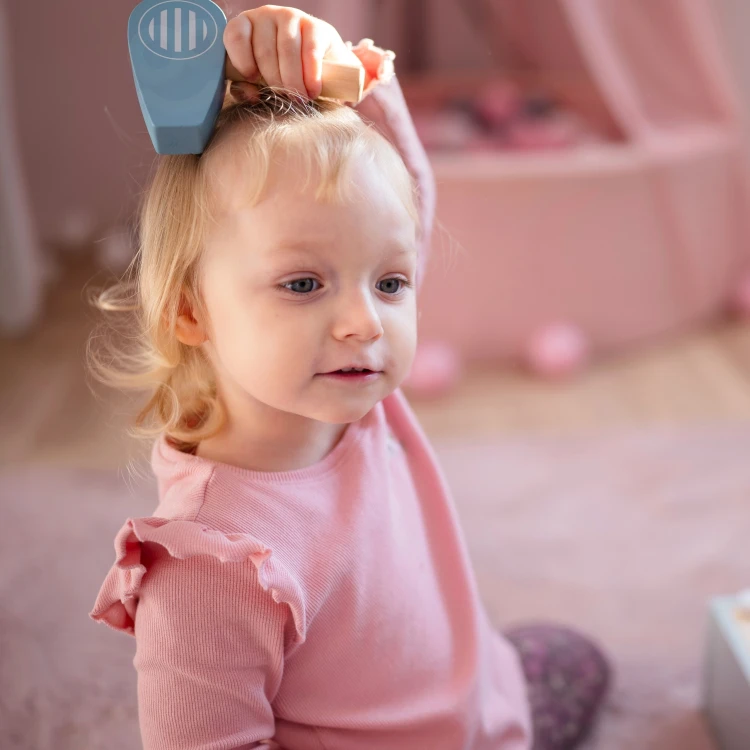 Akcesoria łazienkowe do zabawy — szczotka i kubek obok drewnianej toalety TOOKY TOY ułożone schludnie.