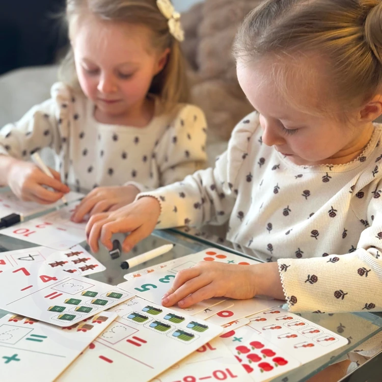 Zbliżenie na rozłożone karty WOOPIE — kolorowe ilustracje i cyfry ułatwiające liczenie