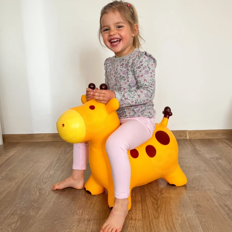 Skoczek WOOPIE — boczny widok żyrafy pokazujący uchwyty do trzymania i kształt siedziska