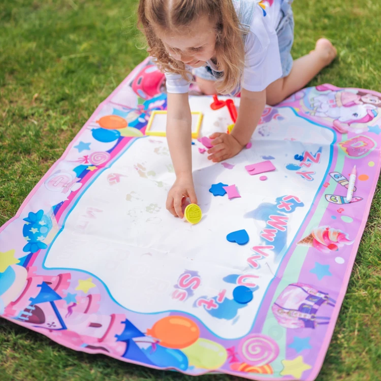 Scena zabawy z matą WOOPIE XXL 100x70cm — dziecko maluje na rozłożonej powierzchni maty