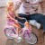 Boczny widok Lalki Lily WOOPIE — sylwetka w foteliku rowerowym pokazana w naturalnej pozie