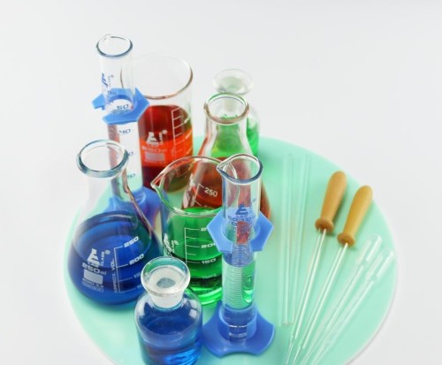 Zbliżenie na szczegóły zestawu: pipety Pasteura, zakraplacze szklane oraz butelka laboratoryjna 125 ml z korkiem