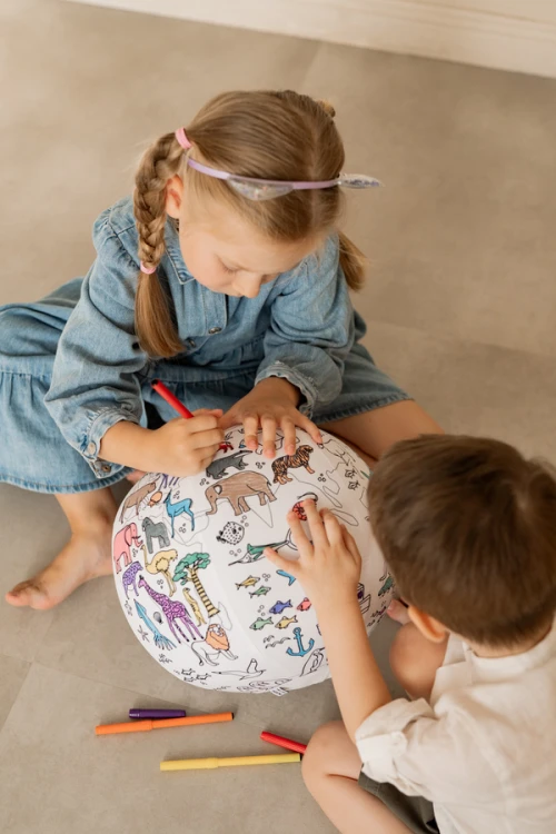Piłka Balonowa Globus Akson w użyciu podczas zajęć edukacyjnych — dzieci kolorują i wskazują kontynenty na powierzchni piłki