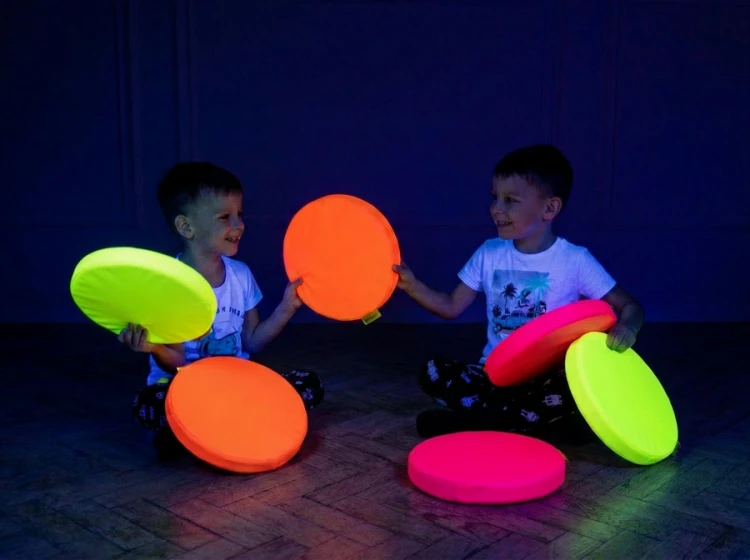 Poduszki Neon UV Akson podczas zabawy — dzieci układają poduszki w kręgu