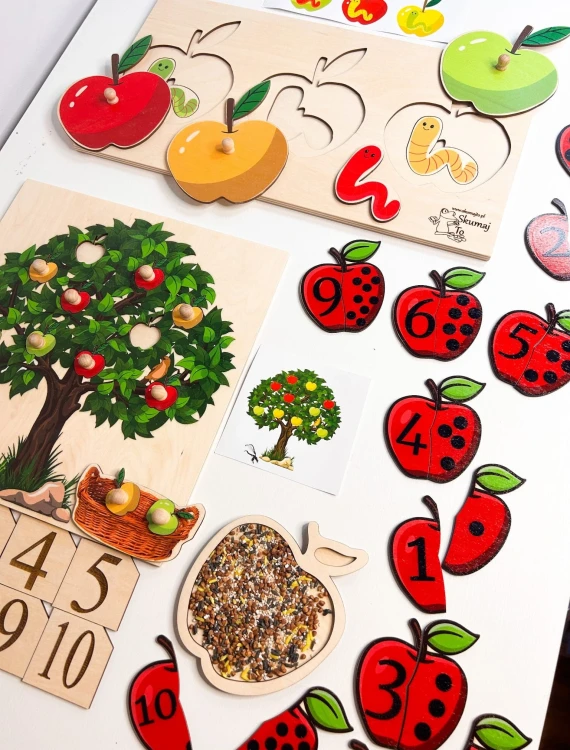 Dziecko układające jabłuszka na drewnianym drzewku z zestawu edukacyjnego EDUBOBO