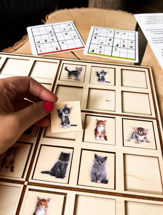 Zbliżenie na karty startowe i elementy drewnianej gry Sudoku z kotami EDUBOBO