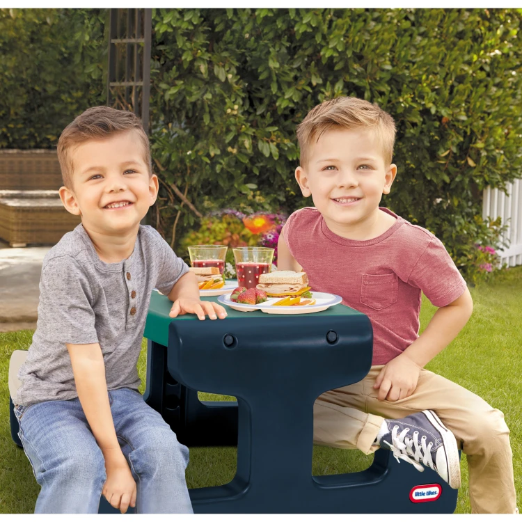 Stolik LITTLE TIKES ustawiony na trawie w ogrodzie, idealny do zabawy na świeżym powietrzu