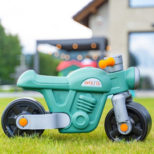 Zielony jeździk Moto Premier FALK z szerokimi kołami na jasnym tle, detal kół
