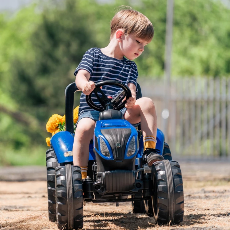 Widok z boku na traktor New Holland T8 na pedały z odczepianą przyczepą FALK