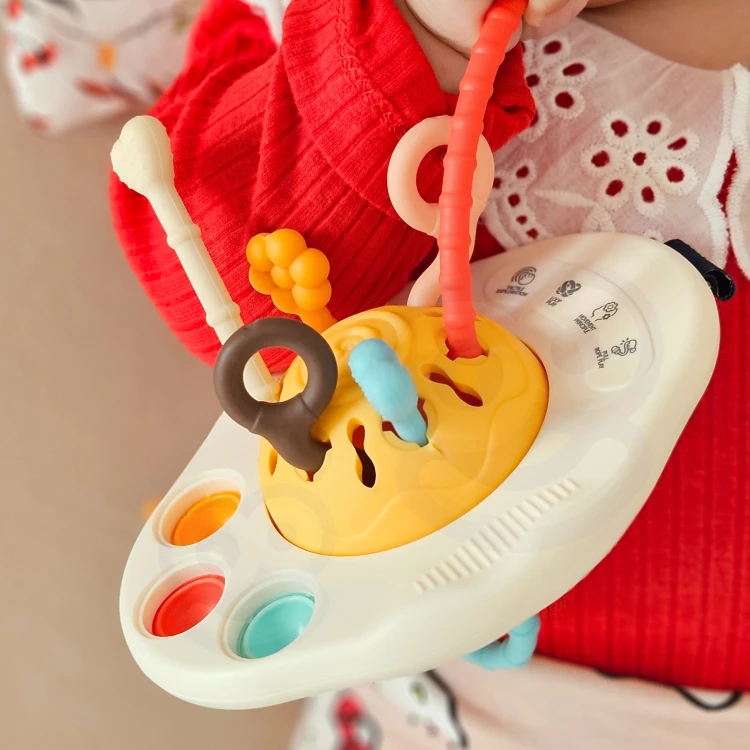 Zbliżenie na sznurki sensoryczne o odmiennych fakturach w zabawce Woopie Baby