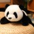 Panda w aranżacji sypialni pokazująca zastosowanie pluszaka podczas odpoczynku i przygotowań do snu