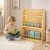 TOOKY TOY regał na książki 58 x 18 x 80 cm ustawiony w pokoju dziecięcym obok zabawek