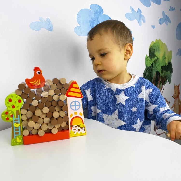 Dziecko podczas zabawy drewnianą grą Farma Spadająca Kura TOOKY TOY
