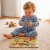 Zestaw drewnianych puzzli TOOKY TOY z planszą i elementami w kształcie dinozaurów oraz jajka z uchwytami