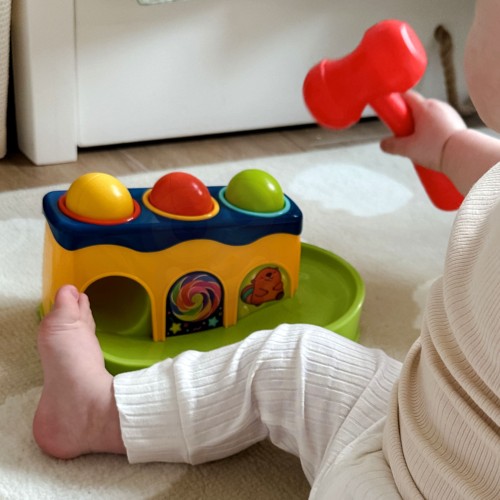 Detal kolorowej przebijanki Woopie Baby z widocznym młoteczkiem i otworami na kulki