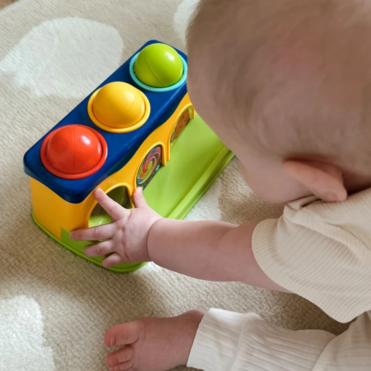 Zbliżenie na młoteczek do przebijanki Woopie Baby z kolorowym uchwytem